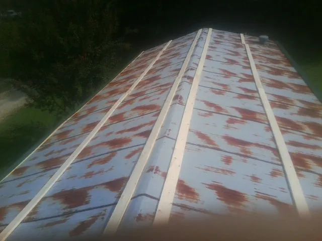 Rusted metal roof panels with new wood purlins before replacement — Storm Damage Roof Repair in Center Moriches by Roofing Brothers