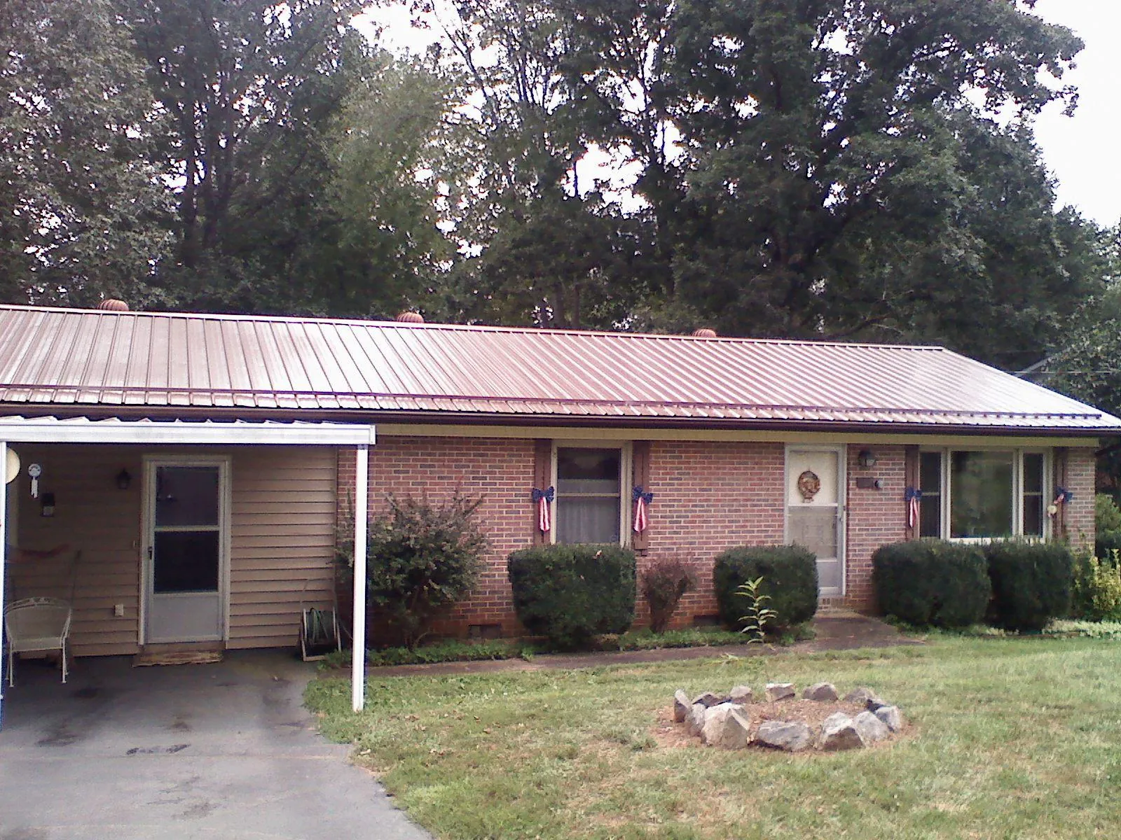 Bronze metal roof and carport on a brick ranch home — Roof Repair work by our crew in Center Moriches